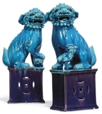 A PAIR OF CHINESE TURQUOISE AND AUBERGINE GLAZED BUDDHISTIC LIONS