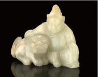 A PALE CALEDON JADE GROUP OF A MAN AND BUDDHISTIC LION, 18TH/19TH CENTURY