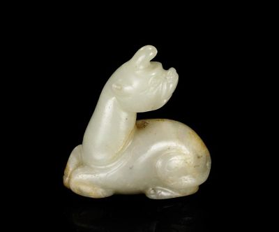 SONG DYNASTY A PALE CELADON AND RUSSET JADE CARVING OF A MYTHICAL BEAST