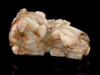 MING DYNASTY A GREY AND RUSSET JADE BUDDHISTIC LION